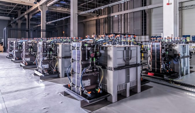 A room full of large rectangular metal boxes attached to mechanical equipment