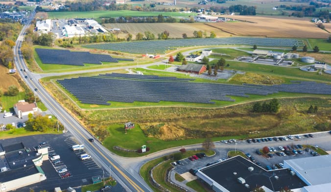 An aerial shot of parking lots, buildings, and a large solar project in a field.