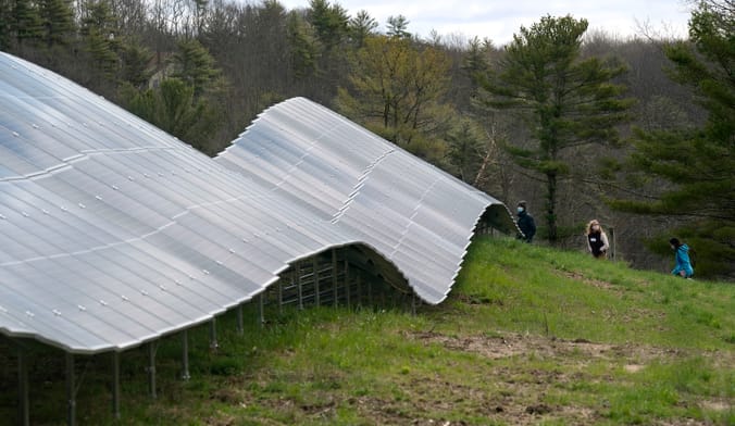 A wavy row of solar panels on a grassy field