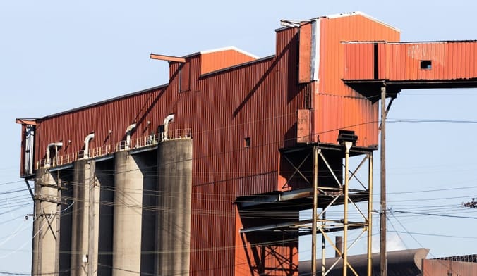 A red industrial building against a blue sky.