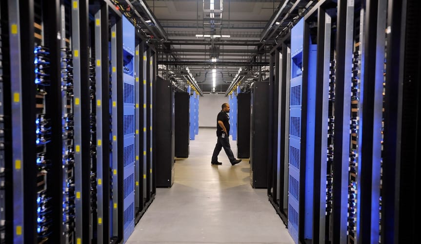 A person walks past rows of hardware in a warehouse