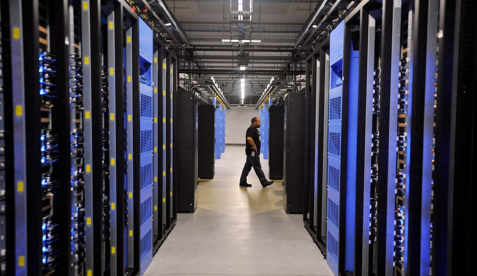 A person walks past rows of hardware in a warehouse