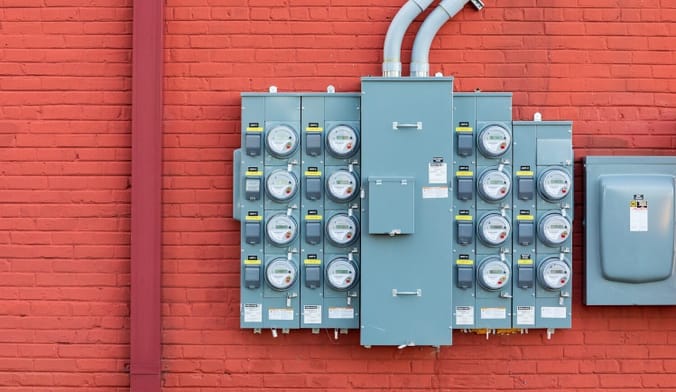 Gray metal boxes mounted on a red brick wall