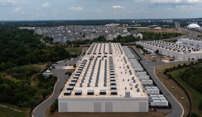 A large warehouse building surrounded by homes