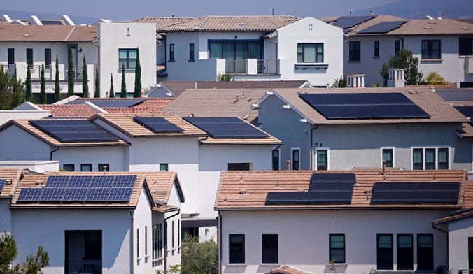 Shot of white and orange homes with solar panels on the roofs