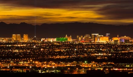 Distant skyline of Los Vegas strip at sunset with backdrop of mountains
