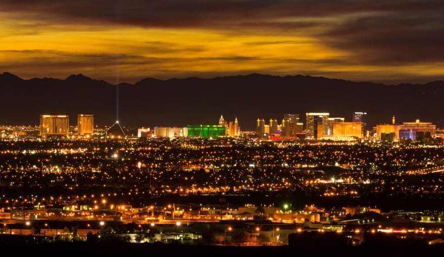 Distant skyline of Los Vegas strip at sunset with backdrop of mountains
