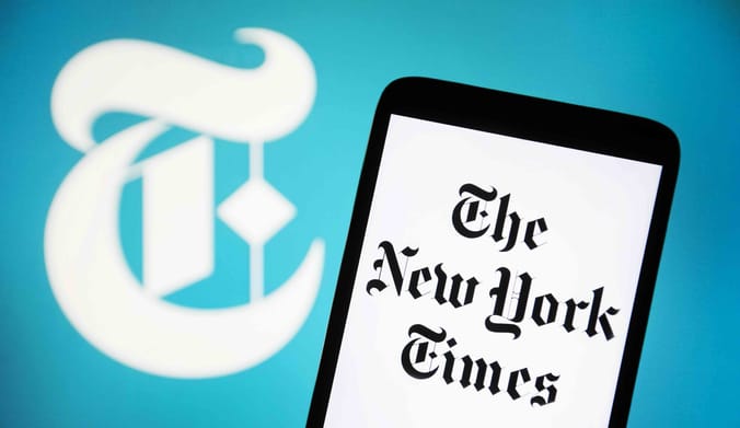 New York Times masthead on a smart phone with the Times' signature "T" in the background