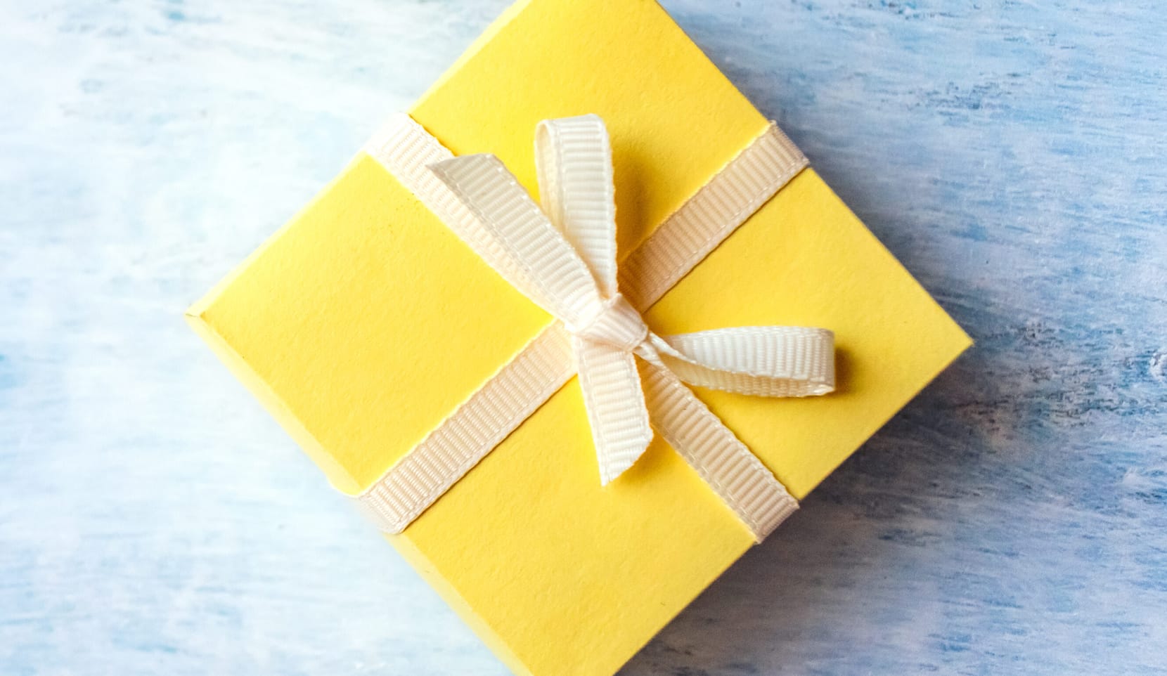 A yellow gift-wrapped package on a blue background