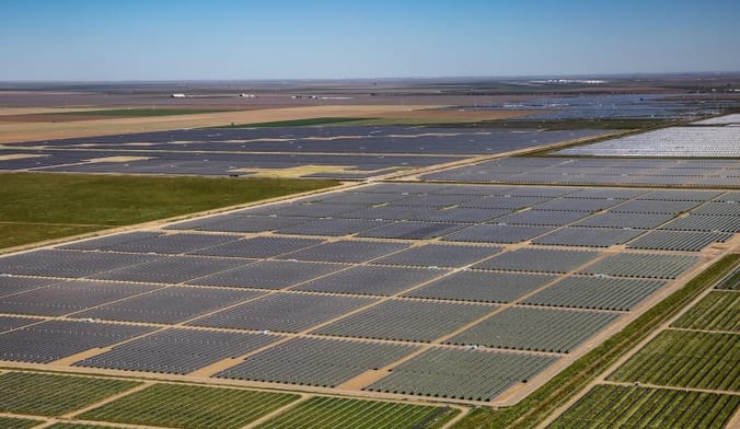 Aerial shot of a large solar farm surrounded by farmland.