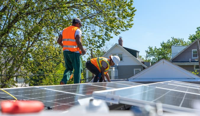 workers installing rooftop solar panels