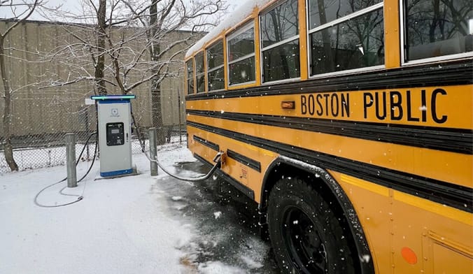 Blue Bird electric school bus charges from a bidirectional EV charger in the Dorchester neighborhood of Boston, Massachusetts