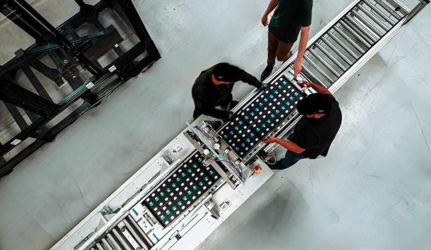 Aerial shot of people standing next to an assembly line