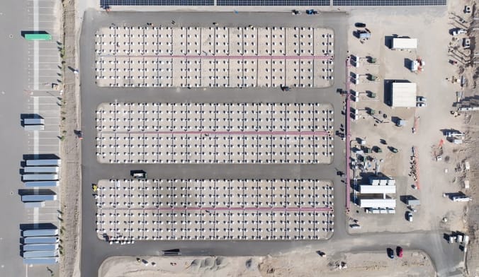 Aerial shot of array of boxes lined up in desert landscape