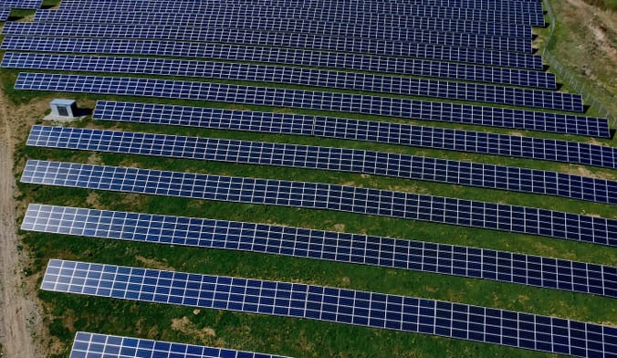 Aerial shot of rows of solar panels in a field