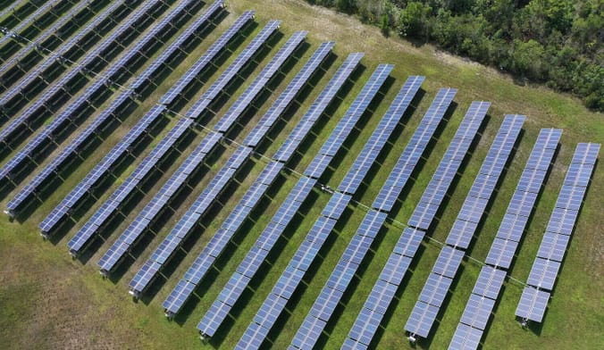 Aerial shot of rows of solar panels on a field