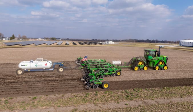 A tractor operated by Landus spreads fertilizer made by Talusag's solar-powered green ammonia facility in Boone, Iowa.
