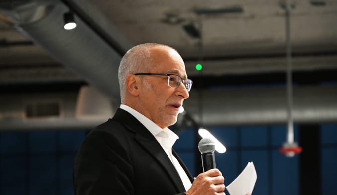 white guy in suit with microphone