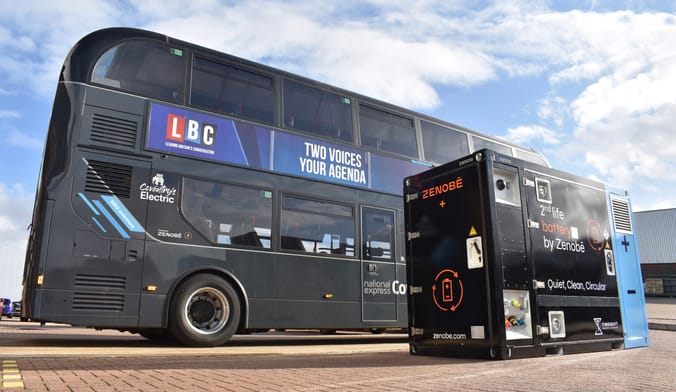 An electric bus next to a 1.2-megawatt-hour storage system built of second-life batteries